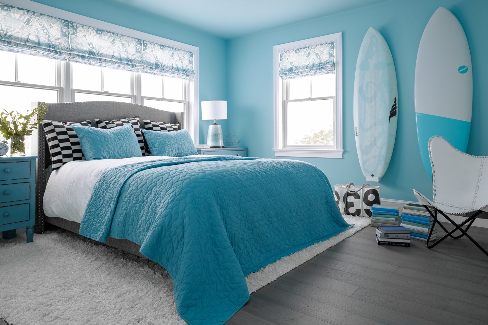 Wide-angle editorial interior photograph of an aqua-toned upstairs bedroom — the kind of establishing shot that anchors a website project gallery.