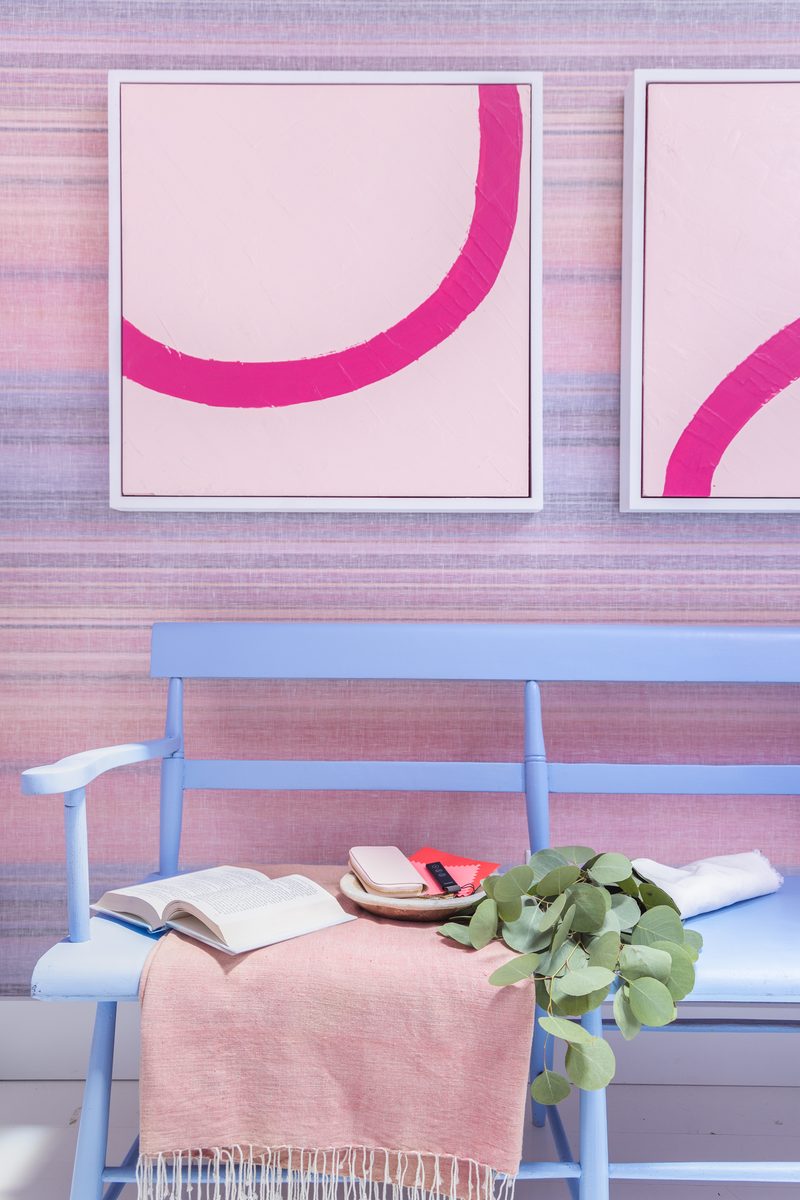 Carefully styled vertical detail shot of a blue bench with pink throw, open book, and abstract artwork — an example of intentional editorial styling for interior photography