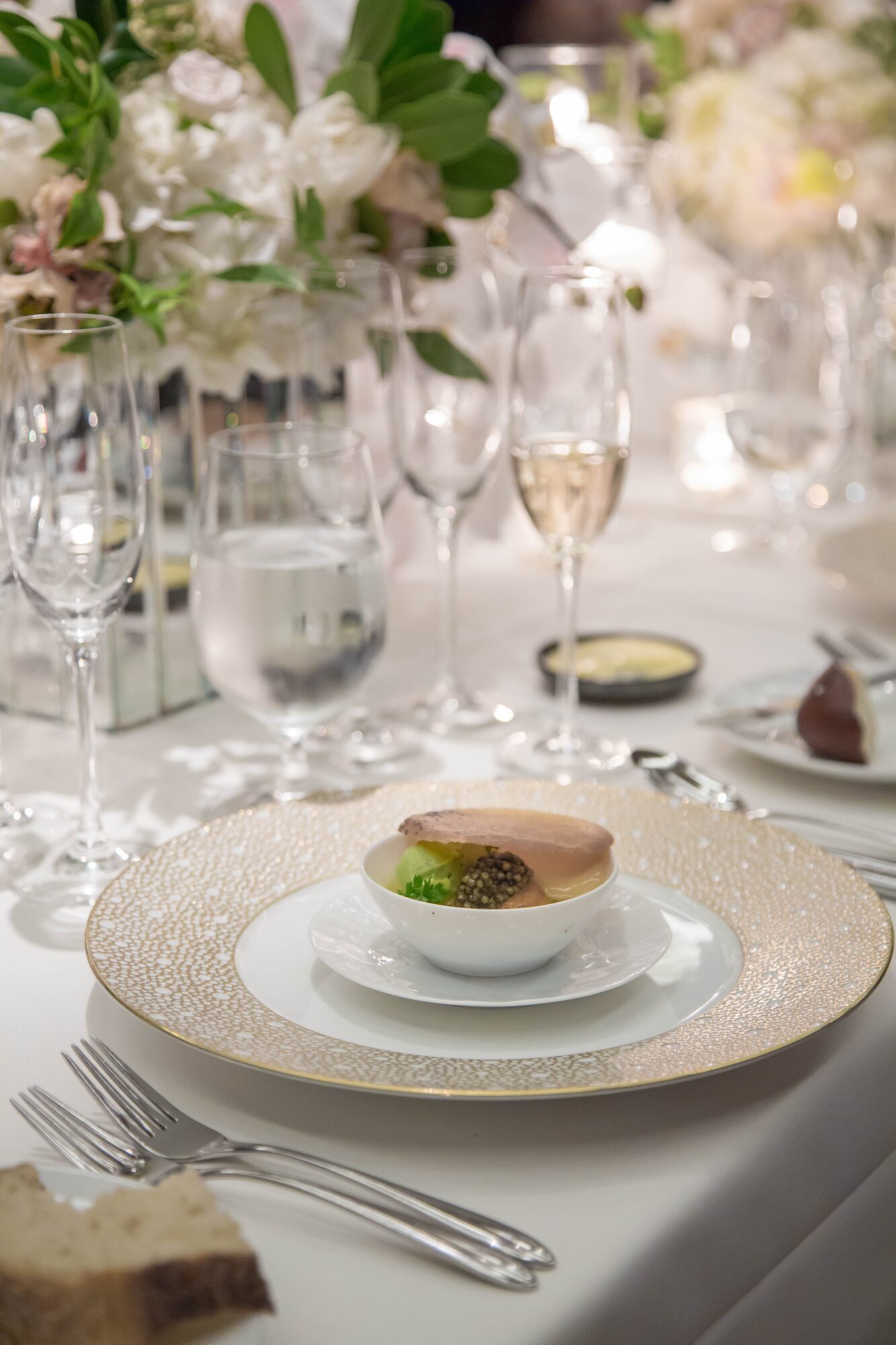 Fine dining place setting with gold-rimmed china and champagne