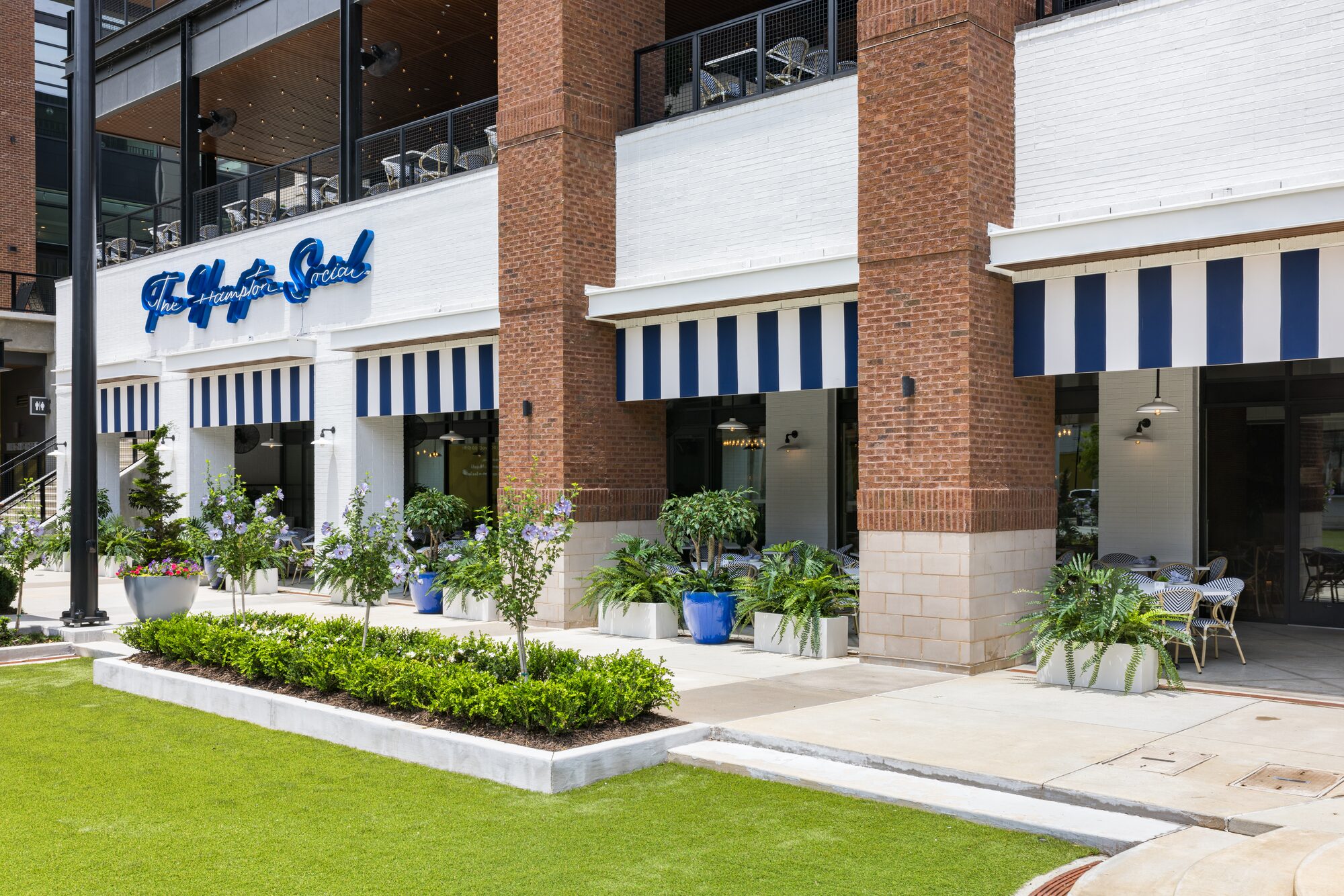 Restaurant exterior with striped awnings and brick facade — hospitality photography