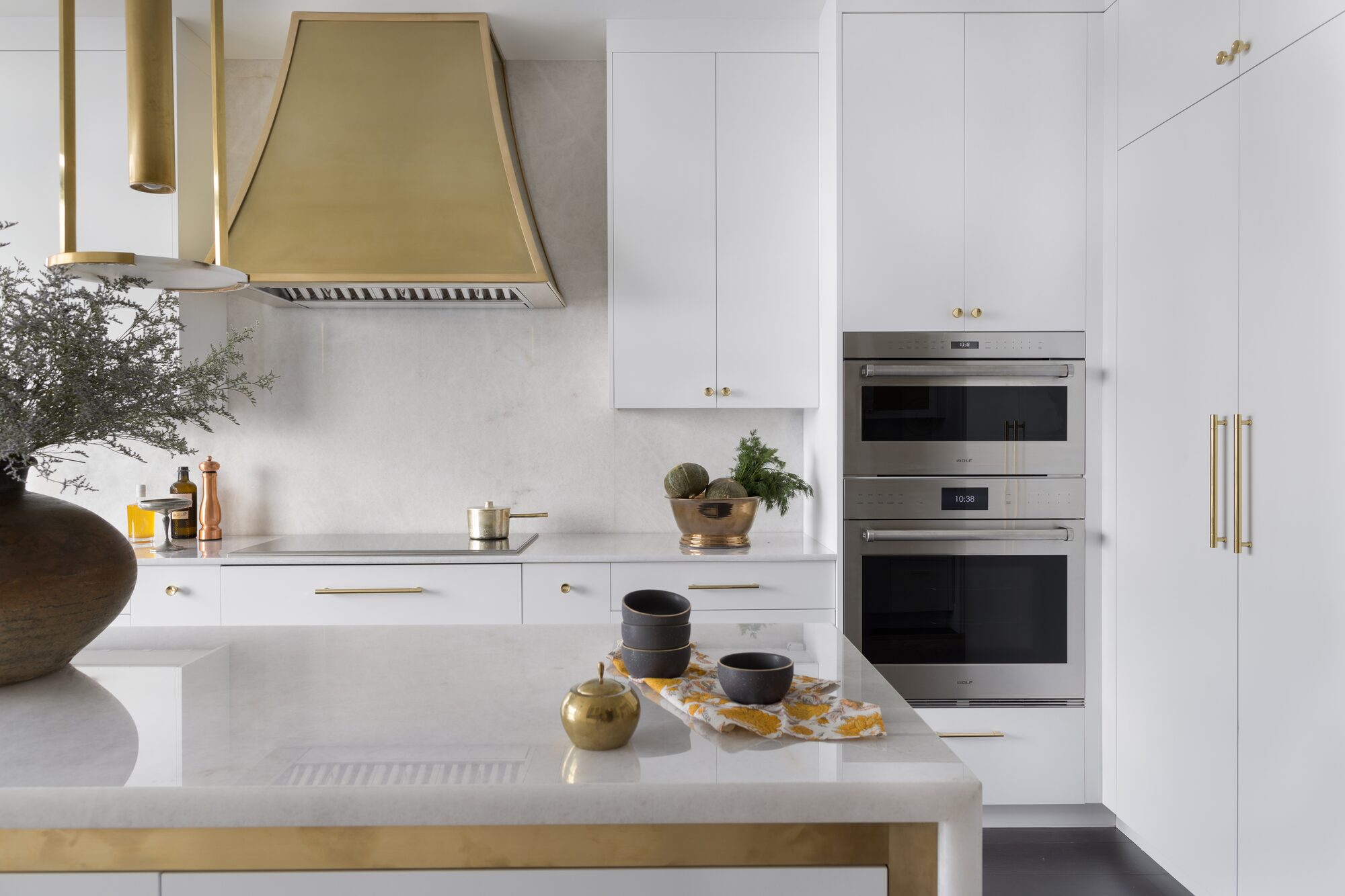 Atlanta modern kitchen with brass range hood and custom cabinetry
