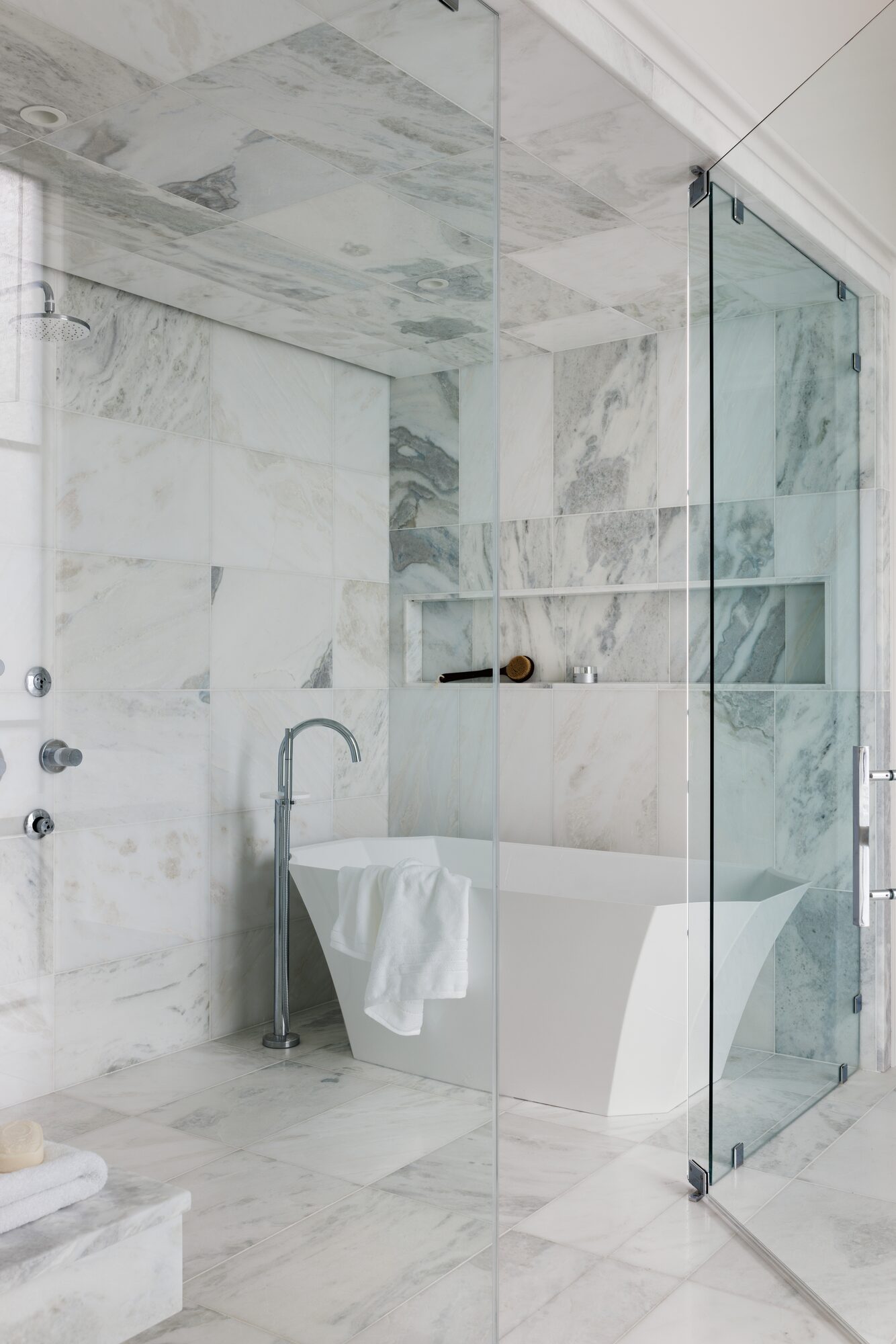 Marble bathroom with glass steam shower and freestanding tub