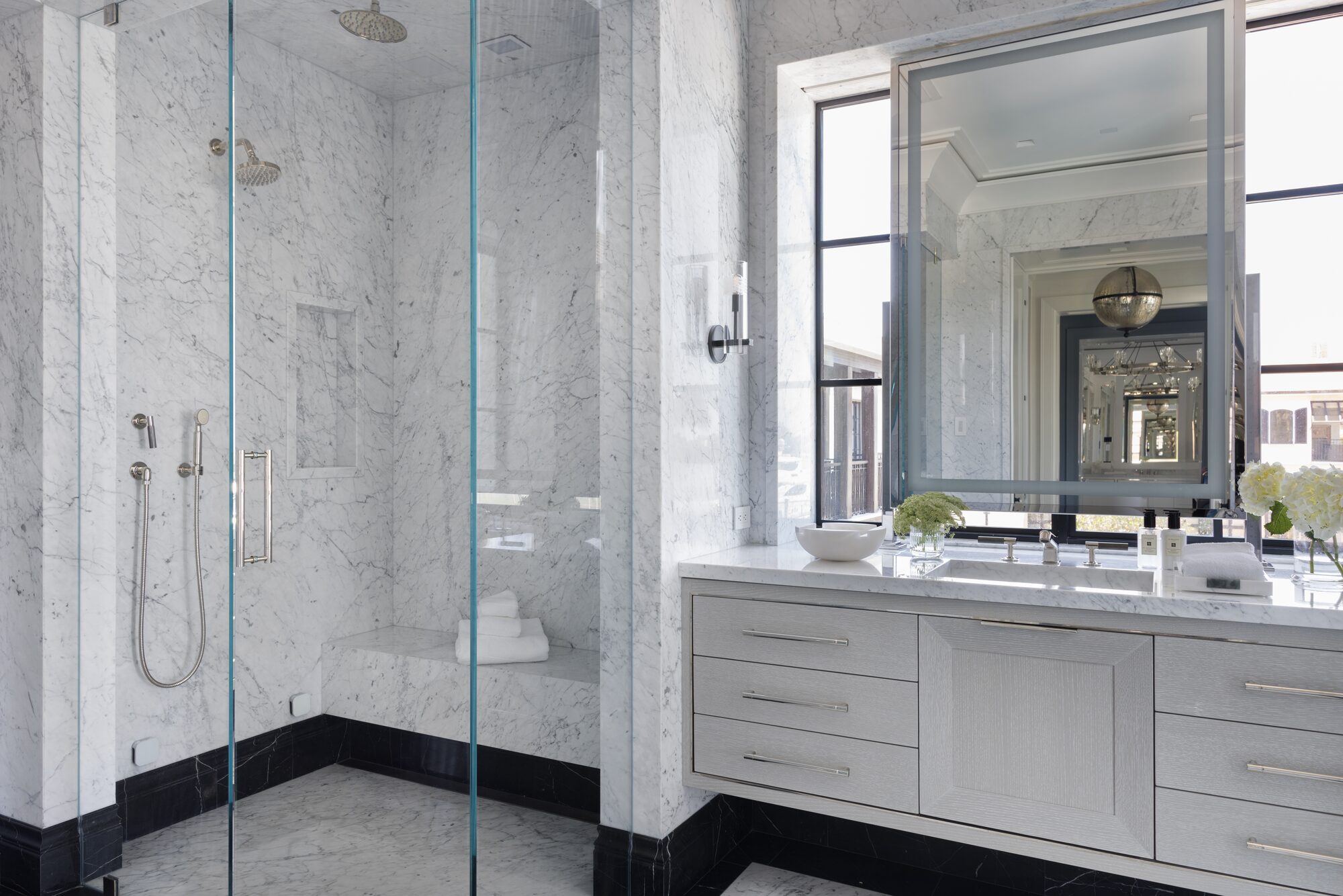 Marble primary bathroom with glass walk-in shower and floating vanity