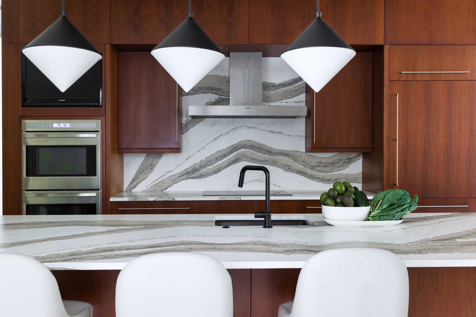 Modern kitchen with waterfall island and stone backsplash