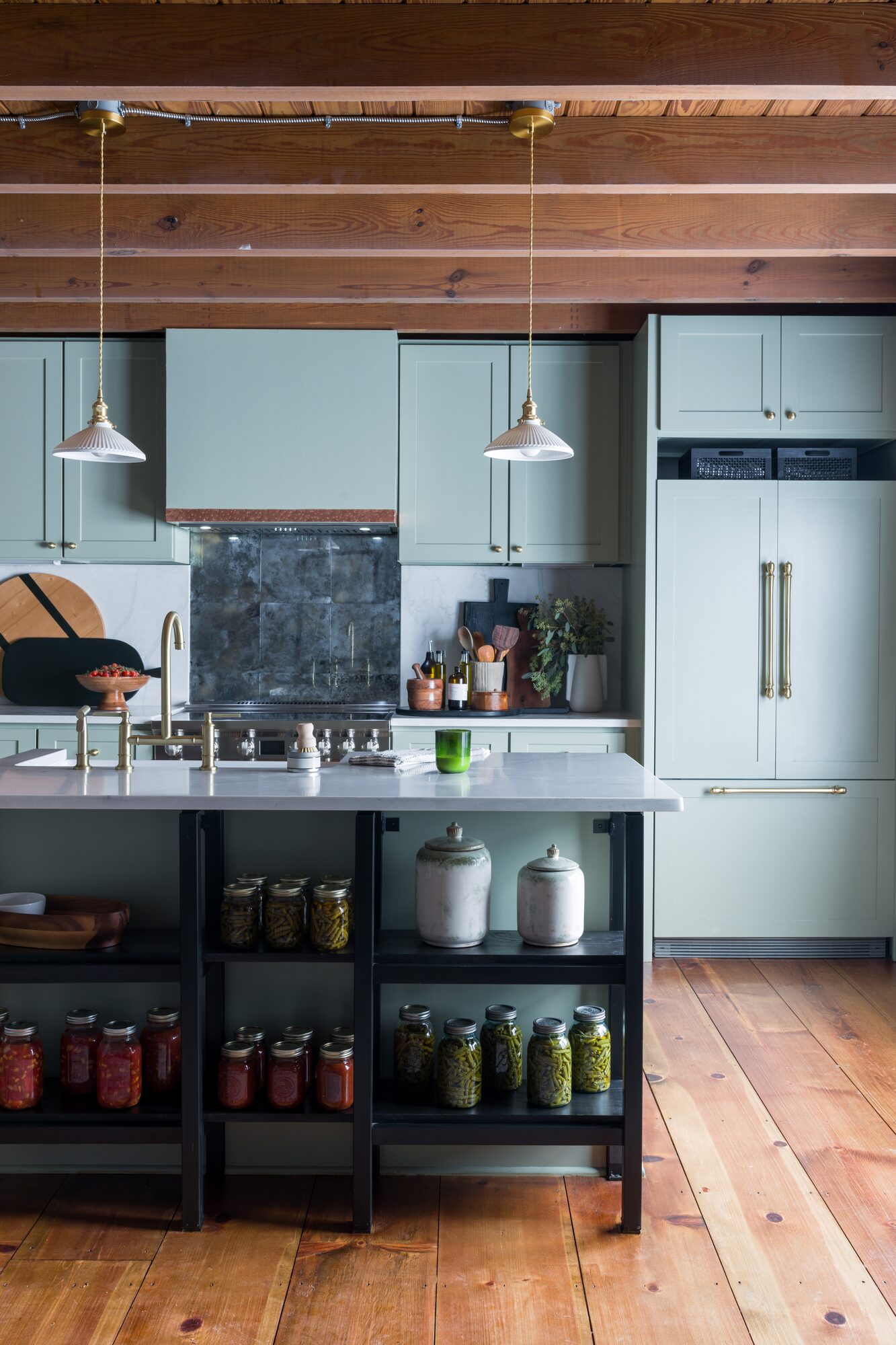 Rustic modern kitchen with sage cabinetry and wood beam ceiling
